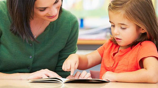 A teacher helping a young student read