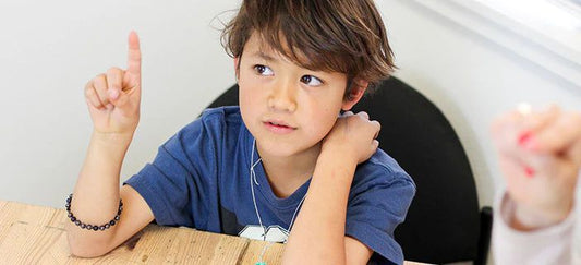 A young student raising his hand with a question