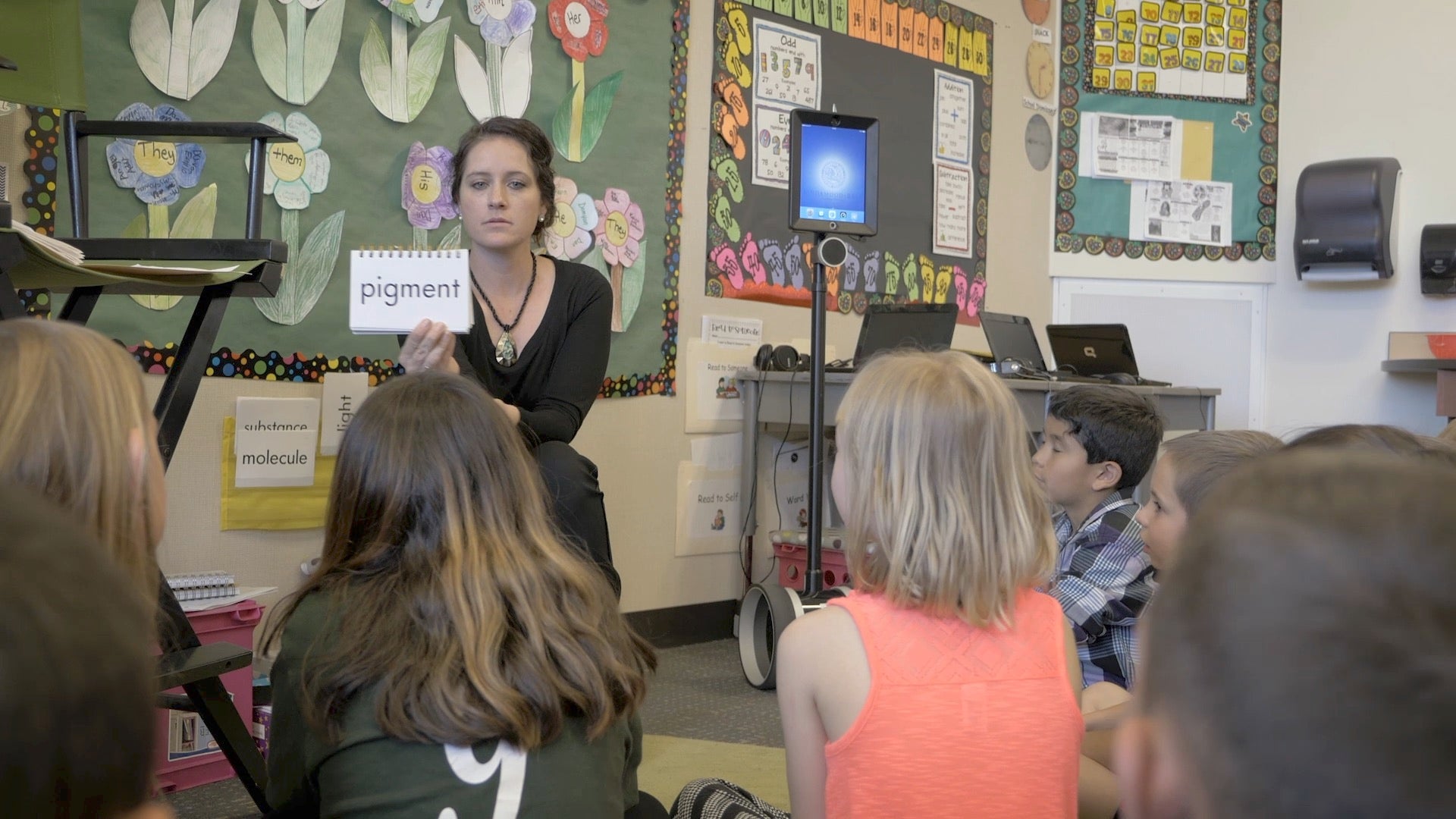 An instructor holding up a word card in a classroom of young students